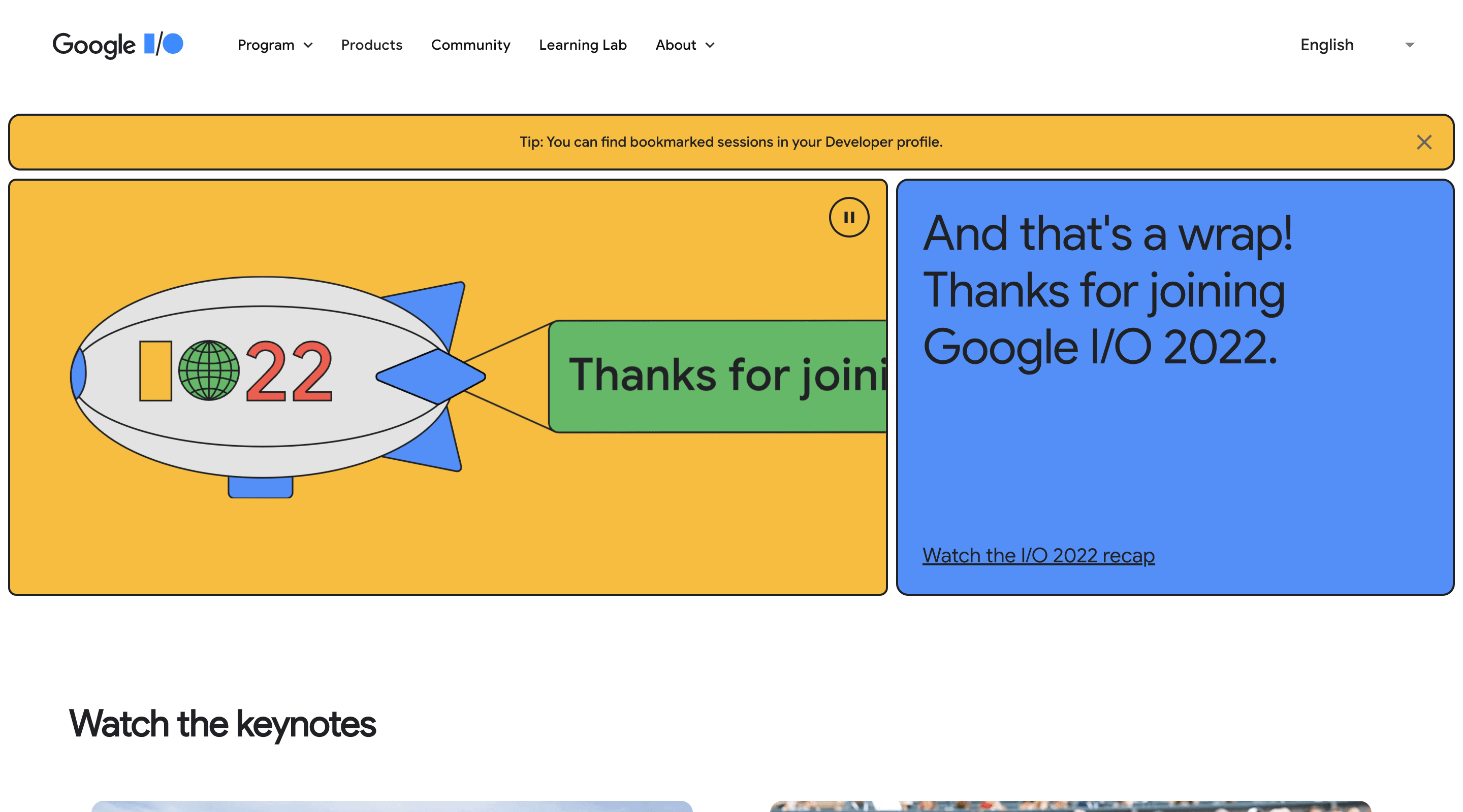 Screenshot of the Google I/O 2022 home page. The header contains the Google I/O logo, the main navigation, and a language selector. The hero section contains an illustration of a blimp with 'IO22' written on the side. The blimp is towing a banner that says 'Thanks for joining'.